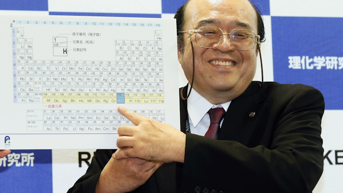 Kosuke Morita of Riken Nishina Center for Accelerator-Based Science points at periodic table of the elements during a press conference in Wako, Saitama prefecture, near Tokyo Thursday, Dec. 31, 2015. (Kyodo News via AP)