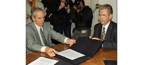 In this July 7, 1997, file photo, American millionaire Douglas Tompkins, left, and Juan Villarzu, chief of staff of the Chilean president, hold the text of an accord signed in Santiago, Chile. Officials in Chile said Tuesday, Dec. 8, 2015, that the wealthy U.S. businessman and environmental activist has died from severe hypothermia in a kayaking accident. (AP Photo/Santiago Llanquin, File)