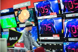 In this Nov. 27, 2015 file photo, a holiday shopper browses the electronics section against a backdrop of televisions at a Target store, in Newport, Ky. Factory orders for long-lasting goods such as autos, airplanes and electronics were flat in November, as the impact of a strong dollar and struggling global economy weigh on U.S. manufacturers. The Commerce Department says that orders for durable goods were nearly unchanged in November after a 2.9 percent increase in October. Demand for autos, electronic products and fabricated metals accelerated last month, but their gains were offset by declines in machinery and aircraft. (AP Photo/John Minchillo, File)