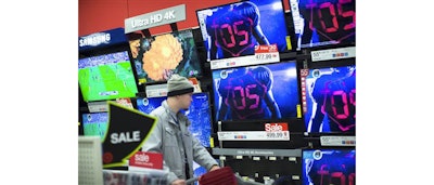 In this Nov. 27, 2015 file photo, a holiday shopper browses the electronics section against a backdrop of televisions at a Target store, in Newport, Ky. Factory orders for long-lasting goods such as autos, airplanes and electronics were flat in November, as the impact of a strong dollar and struggling global economy weigh on U.S. manufacturers. The Commerce Department says that orders for durable goods were nearly unchanged in November after a 2.9 percent increase in October. Demand for autos, electronic products and fabricated metals accelerated last month, but their gains were offset by declines in machinery and aircraft. (AP Photo/John Minchillo, File)