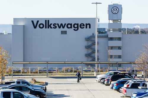 A man walks through the employee parking lot at the Volkswagen plant in Chattanooga, Tenn., on Friday, Dec. 4, 2015. (AP Photo/Erik Schelzig)