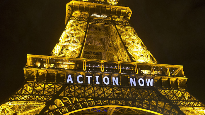 The Eiffel Tower lights up with the slogan “Action Now” referring to the COP21, United Nations Climate Change Conference in Paris on Sunday. (Michel Euler/AP)