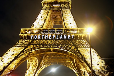 The slogan 'FOR THE PLANET' is projected on the Eiffel Tower as part of the COP21, United Nations Climate Change Conference in Paris, France, Friday, Dec. 11, 2015. (AP Photo/Francois Mori)