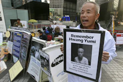 Hwang Sang-gi, a founding member of advocacy group Banolim, holds a picture of his daughter Yu-mi during an interview denouncing Samsung’s response in its latest negotiations with sick workers outside Samsung buildings in Seoul, South Korea. Yu-mi’s death from leukemia in 2007 galvanized concern about conditions at Samsung factories and South Korea’s semiconductor industry in general. (AP Photo/Ahn Young-joon)
