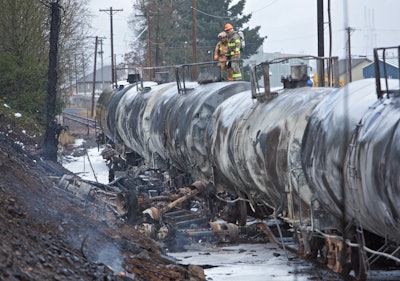 The remains of a fuel tanker truck that crashed into railroad cars is seen near the St. Johns Bridge in Portland, Ore., Sunday, Dec. 13, 2015. (AP Photo/Craig Mitchelldyer)