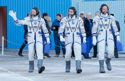 British astronaut Tim Peake, left, Russian cosmonaut Yuri Malenchenko, center, and U.S. astronaut Tim Kopra, members of the main crew of the expedition to the International Space Station (ISS), walk to report to members of the State Committee prior to the launch of Soyuz TMA-19M space ship at the Russian leased Baikonur cosmodrome, Kazakhstan, Tuesday, Dec. 15, 2015. (AP Photo/Dmitry Lovetsky, Pool)