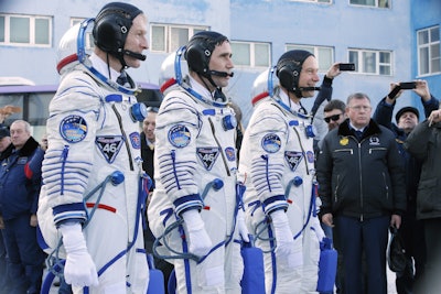 British astronaut Tim Peake, left, Russian cosmonaut Yuri Malenchenko, center, and U.S. astronaut Tim Kopra, members of the main crew of the expedition to the International Space Station (ISS), report to members of the State Committee prior to the launch of Soyuz TMA-19M space ship at the Russian leased Baikonur cosmodrome, Kazakhstan, Tuesday, Dec. 15, 2015. (AP Photo/Dmitry Lovetsky, Pool)