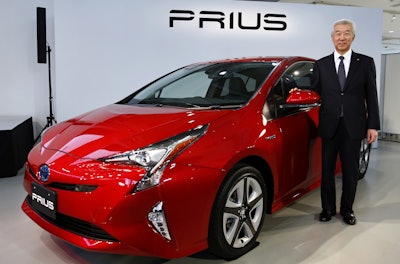 Toyota Motor Corp. Executive Vice President Mitsuhisa Kato poses with a Toyota new Prius at the Toyota showroom in Tokyo, Japan. (AP Photo/Shizuo Kambayashi)