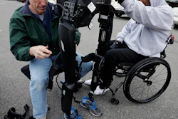 ReWalk Robotics service engineer Tom Coulter prepares a ReWalk device to allow paralyzed Army veteran Gene Laureano to walk Wednesday, Dec. 16, 2015, in Bronx, N.Y. (AP Photo/Mel Evans)