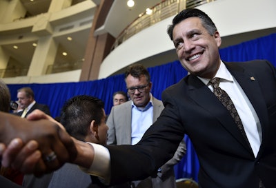 Nevada Gov. Brian Sandoval shakes hands with attendees after a news conference in Las Vegas. Dag Reckhorn, Faraday Future's global vice president of manufacturing, is at center rear. (AP Photo/David Becker, File)