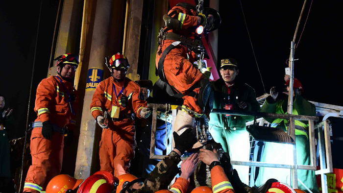 The first miner, is lifted from a collapsed mine in Pingyi, east China's Shandong Province, Friday evening Jan. 29, 2016. Chinese state media say two miners have been rescued from a collapsed mine after spending 36 days trapped underground. Efforts continued Friday to reach the remaining two people in the mine in east China's Shandong province. The gypsum mine collapsed on Christmas Day, killing one and leaving 13 others missing. In the days that followed, rescuers detected four survivors 200 meters (660 feet) below the surface. (Guo Xulei/Xinhua via AP)