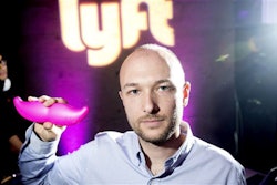 In this Monday, Jan. 26, 2015, file photo, Logan Green, co-founder and chief executive officer of Lyft, displays his company's 'glowstache' during a launch event in San Francisco. On Monday, Jan. 4, 2016, General Motors Co. announced it is investing $500 million in ride-sharing company Lyft Inc. GM gets a seat on Lyft’s board as part of the partnership, which could speed the development of on-demand, self-driving cars. (AP Photo/Noah Berger, File)