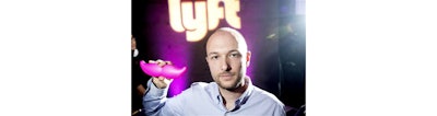 In this Monday, Jan. 26, 2015, file photo, Logan Green, co-founder and chief executive officer of Lyft, displays his company's 'glowstache' during a launch event in San Francisco. On Monday, Jan. 4, 2016, General Motors Co. announced it is investing $500 million in ride-sharing company Lyft Inc. GM gets a seat on Lyft’s board as part of the partnership, which could speed the development of on-demand, self-driving cars. (AP Photo/Noah Berger, File)