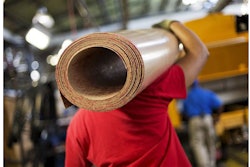 In this Friday, Sept. 18, 2015, photo, a worker carries a roll of sub flooring to be installed in a school bus on an assembly line at Blue Bird Corporation's manufacturing facility, in Fort Valley, Ga. The Institute for Supply Management, a trade group of purchasing managers, issues its index of manufacturing activity for December, on Monday, Jan. 4, 2016. (AP Photo/David Goldman)