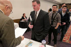 In this April 22, 2015 photo, Ralph Logan, general manager of Microtrain, left, speaks with James Smith who is seeking employment during a National Career Fairs job fair in Chicago. For months, U.S. employers have steadily added jobs even as global growth has flagged and financial markets have sunk. The jobs report for December on Friday, Jan. 8, 2016, may provide some hints of whether that trend can endure. (AP Photo/M. Spencer Green)