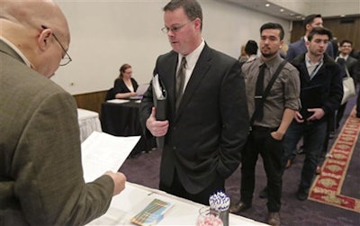 In this April 22, 2015 photo, Ralph Logan, general manager of Microtrain, left, speaks with James Smith who is seeking employment during a National Career Fairs job fair in Chicago. For months, U.S. employers have steadily added jobs even as global growth has flagged and financial markets have sunk. The jobs report for December on Friday, Jan. 8, 2016, may provide some hints of whether that trend can endure. (AP Photo/M. Spencer Green)