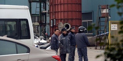 Security personnel stand outside of the Shanghai Zhizhuo Machinery Equipment System Co. Ltd. factory following an explosion in the Baoshan district of Shanghai, China, Wednesday, Jan. 13, 2016. Four Chinese workers were killed Wednesday in an explosion at the machinery factory on the outskirts of Shanghai, a local state-owned newspaper said. (Chinatopix via AP)