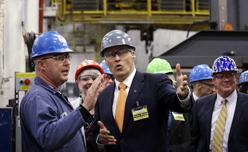 In this Tuesday, Jan. 26, 2016, file photo, Jeff Cuvelier, Jorgensen Forge master machinist, left, talks with Gov. Jay Inslee, center, on a tour of the plant in Seattle. On Friday, Jan. 29, 2016, the Commerce Department issues the first of three estimates of how the U.S. economy performed in the October-December quarter. (AP Photo/Elaine Thompson, File)