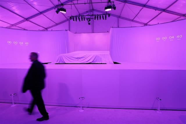 A man passes by the FFZero1 by Faraday Future, still covered, before it is displayed at CES. (AP Photo/Gregory Bull)