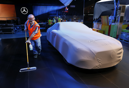 Carpenter Andy Assenmacher cleans the floor at the Mercedes-Benz exhibit. (AP Photo/Paul Sancya)