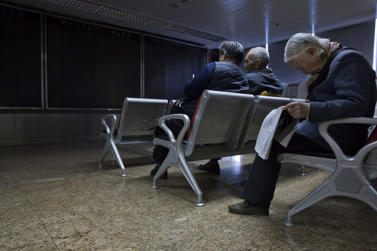 Investors gather near a darkened stock price display boards after trading was halted at a brokerage in Beijing, China. (AP Photo/Ng Han Guan, File)