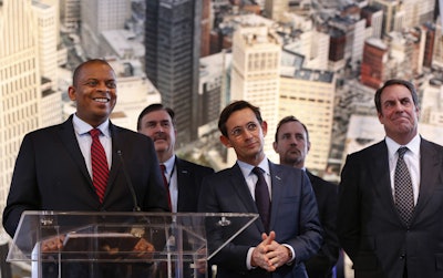 U.S. Transportation Secretary Anthony Foxx, left, listens to a question with auto executives at the North American International Auto Show in Detroit. (AP Photo/Paul Sancya)