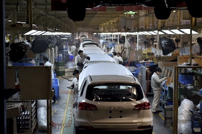 Chinese workers labor on the assembly line of the X5 SUV of Zotye Auto in Hangzhou in east China's Zhejiang province. (Chinatopix via AP)