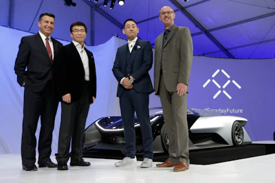 Nevada Gov. Brian Sandoval, left, poses for a photo in front of the FFZero1 by Faraday Future, alongside members of the Faraday Future team. (AP Photo/Gregory Bull, File)