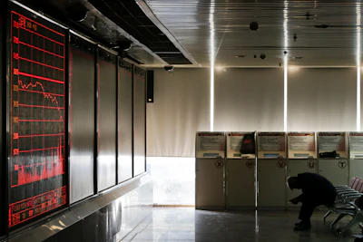 A man sits near an electronic board displaying stock prices at a brokerage house in Beijing, Tuesday, Jan. 26, 2016. Asian stock markets sank Tuesday, led by a plunge in the Shanghai index, after a renewed slump in the price of oil kept investors on edge about the global economy. (AP Photo/Andy Wong)