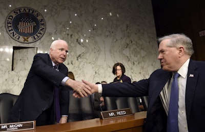 Senate Armed Services Committee Chairman Sen. John McCain, R-Ariz., left, shakes hands with Defense Undersecretary Frank Kendall, the military's chief weapons buyer, right, before the start of a hearing on Capitol Hill in Washington, Wednesday, Jan. 27, 2016, on Russian-made rockets for military satellites. At a committee hearing, McCain said Russia holds many of the United States' 'most precious national security satellites at risk before they ever get off the ground.' (AP Photo/Susan Walsh)
