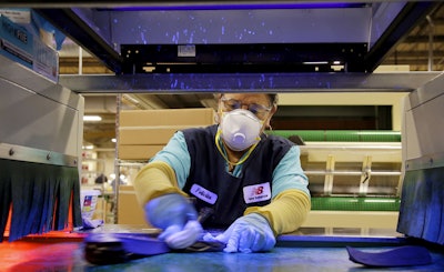 In this Wednesday, July 1, 2015, file photo, primer is applied to the midsole of a military tested New Balance 950v2 sneaker under ultraviolet light before the outsole is attached at one of company's manufacturing facilities in Boston. On Monday, Feb. 1, 2016, the Institute for Supply Management, a trade group of purchasing managers, issues its index of manufacturing activity for January. (AP Photo/Stephan Savoia, File)