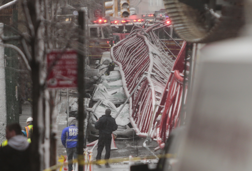 A collapsed crane lies on the street on Friday, Feb. 5, 2016, in New York. The crane landed across an intersection and stretched much of a block in the Tribeca neighborhood, about 10 blocks north of the World Trade Center. (AP Photo/Bebeto Matthews)
