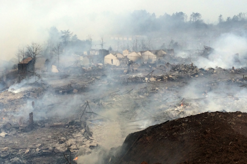 Smoke rises over the rubble of a fireworks factory after an explosion near Shangrao in southern China's Jiangxi province Wednesday Jan. 20, 2016. A massive explosion Wednesday at a fireworks plant in southern China killed several people and injured dozens more while shattering windows of homes in the area, officials and state media reports said. (Chinatopix via AP) CHINA OUT