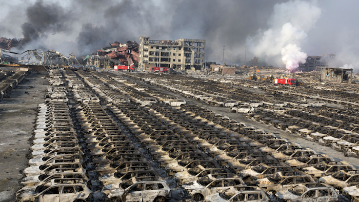 In this Aug. 13, 2015 file photo, smoke billows from the site of an explosion that reduced a parking lot filled with new cars to charred remains at a warehouse in northeastern China's Tianjin municipality. Deadly warehouse blasts that killed 165 people in a Chinese port city in August last year were triggered when a chemical stored in an unlicensed facility became too dry and caught fire, investigators announced Friday, Feb. 5, 2016. An investigative team assembled by the State Council, China’s Cabinet, said flames spread among stocks of nitrocellulose, a flammable compound used as a binding agent with medical applications and as an ingredient of lacquer. The flames then spread to illegal stores of the combustible fertilizer ammonium nitrate, touching off two massive explosions. (AP Photo/Ng Han Guan, File)