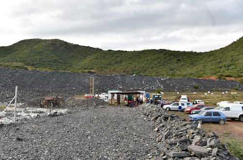 Family members and friends of three missing persons wait outside the Vantage Goldfields Limited's Lily Mine's entrance near Barberton, South Africa, Friday Feb. 5, 2016. A miners' union spokesman in South Africa says three people remain missing after a building collapsed above a gold mine, trapping dozens of people. The spokesman said earlier that 87 people were trapped above and below ground. The cause of the collapse is believed to be a sinkhole, according to emergency services. (AP Photo)