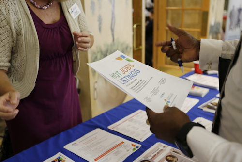 In this Tuesday, Oct. 6, 2015, file photo, a military veteran, at right, talks with a veterans outreach representative about employment opportunities, at a job fair for veterans, in Pembroke Pines, Fla. On Thursday, Feb. 25, 2016, the Labor Department reports on the number of people who applied for unemployment benefits the week before. (AP Photo/Lynne Sladky, File)