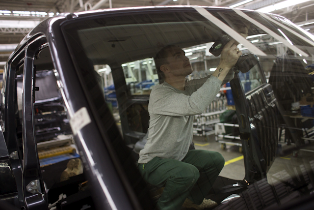 In this photo taken Tuesday, Feb. 16, 2016, a worker builds cars on the assembly line at the UAZ car plant in the city of Ulyanovsk on the Volga River, Russia. Once intended as a Soviet rival to the capitalist symbol of Detroit, Russia’s auto-making hub is sliding into economic depression. (AP Photo/Ivan Sekretarev)