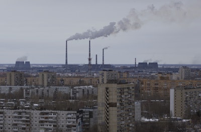 In this photo taken Wednesday, Feb. 17, 2016, buildings of the AvtoVAZ car plant is seen above the residential buildings at the bottom of chimneys in the southern city of Togliatti on the Volga River, Russia. Once intended as a Soviet rival to the capitalist symbol of Detroit, Russia’s auto-making hub is sliding into economic depression. (AP Photo/Ivan Sekretarev)