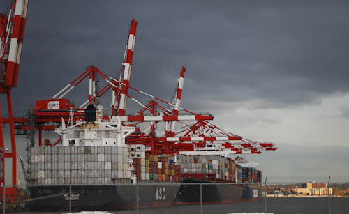 Containers stacked on ships sit idol at Port Newark in Newark, N.J. Friday, Jan. 29, 2016. (AP Photo/Rich Schultz)