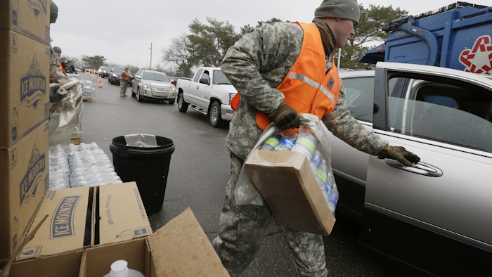 Members of the Michigan National Guard load bottled water for residents at a fire station, Thursday, Jan. 28, 2016 in Flint, Mich. (AP Photo/Carlos Osorio)