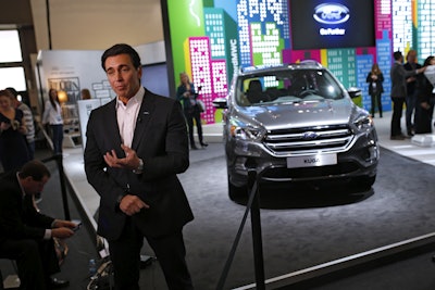 Ford CEO Mark Fields talks during an interview next to the new Kuga SUV car, which features its latest connectivity and driver-assisted technology, during the Mobile World Congress Wireless show, the world's largest mobile phone trade show, in Barcelona, Spain, Monday, Feb. 22, 2016. (AP Photo/Francisco Seco)