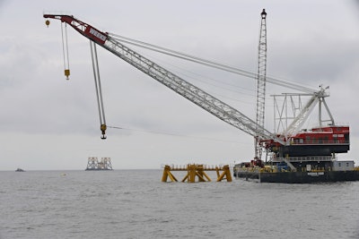 In this July 27, 2015, file photo, the first foundation jacket installed by Deepwater Wind in the nation's first offshore wind farm construction project is seen next to a floating construction crane on the waters of the Atlantic Ocean off Block Island, R.I. Business leaders and politicians who gathered for an industry conference in Boston during early March 2016, pointed to deep-pocketed investors and major European offshore wind companies that are increasingly committing to projects all along the East Coast as evidence that a domestic industry dreamed about for nearly two decades has finally come. (AP Photo/Stephan Savoia, File)
