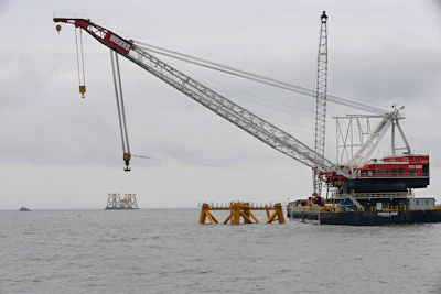 In this July 27, 2015, file photo, the first foundation jacket installed by Deepwater Wind in the nation's first offshore wind farm construction project is seen next to a floating construction crane on the waters of the Atlantic Ocean off Block Island, R.I. Business leaders and politicians who gathered for an industry conference in Boston during early March 2016, pointed to deep-pocketed investors and major European offshore wind companies that are increasingly committing to projects all along the East Coast as evidence that a domestic industry dreamed about for nearly two decades has finally come. (AP Photo/Stephan Savoia, File)