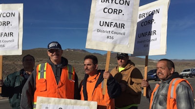 Picketers protest at the Tesla Gigafactory site Monday, Feb. 29, 2016, near Reno, Nev. Hundreds of union construction workers walked off the job at Tesla Motors' battery manufacturing plant in northern Nevada on Monday to protest what union organizers say is the increased hiring of out-of-state workers for less pay. (Anjeanette Damon/The Reno Gazette-Journal via AP)