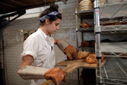 In this Friday, June 5, 2015, file photo, Sarah Hinkes places freshly baked bread onto a rack at Zak the Baker in Miami. On Tuesday, March 15, 2016, the Labor Department reports on U.S. producer price inflation in February. (AP Photo/Lynne Sladky, File)