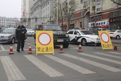 In this March 15, 2016 photo, police vehicles block a road on a street of the prefectural seat of Shuangyashan after several days of protest by miners over late wages in northeastern China's Heilongjiang province. Frustration among miners over unpaid wages has swelled to the brink of unrest in the province in Chinaβs far northeast. (AP Photo/Gerry Shih)