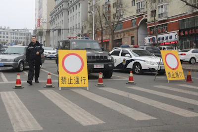 In this March 15, 2016 photo, police vehicles block a road on a street of the prefectural seat of Shuangyashan after several days of protest by miners over late wages in northeastern China's Heilongjiang province. Frustration among miners over unpaid wages has swelled to the brink of unrest in the province in China’s far northeast. (AP Photo/Gerry Shih)