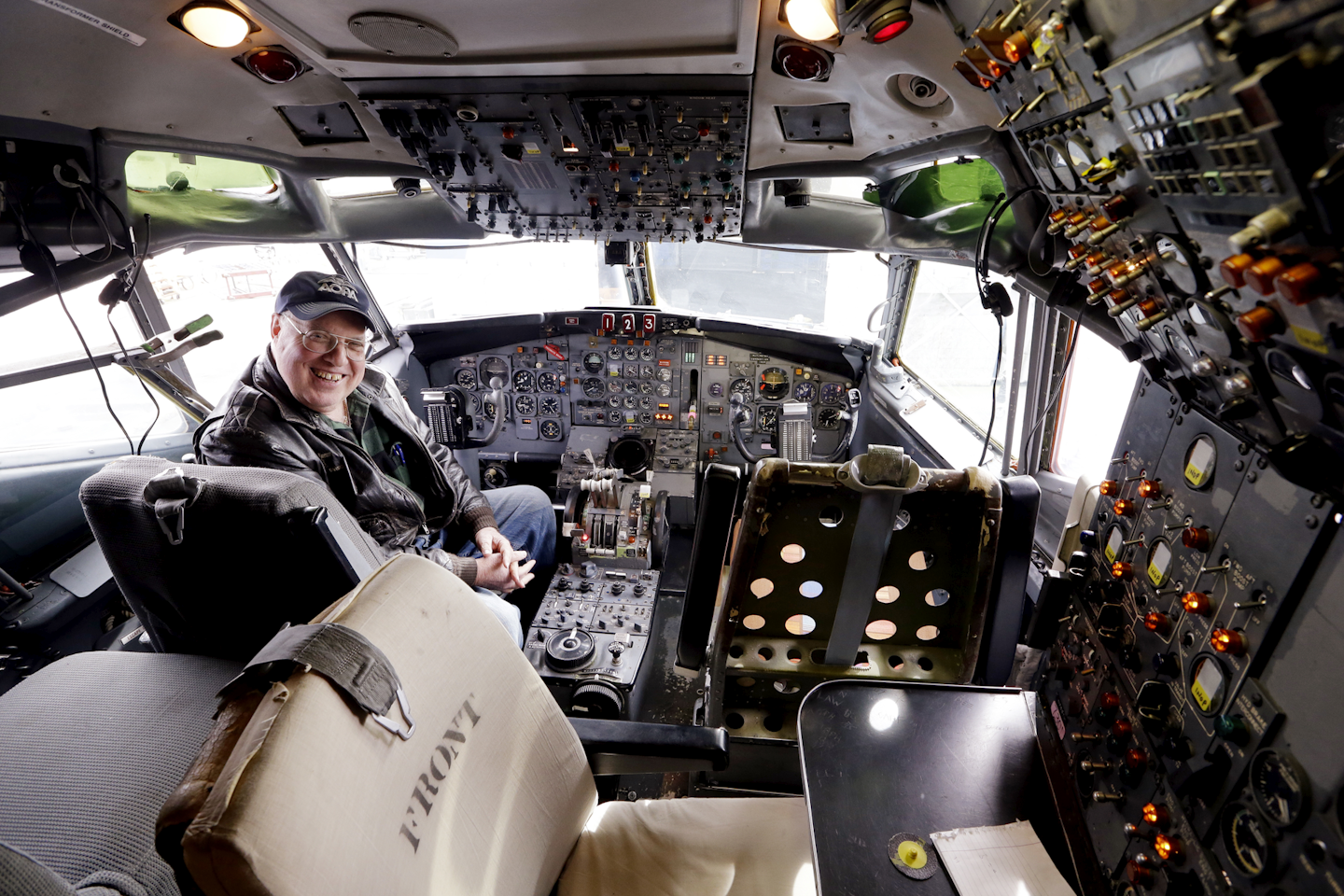 Bob Bogash, a safety officer on the flight, sits in the cockpit of the historic Boeing 727 prototype. (AP Photo/Elaine Thompson)