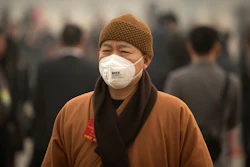 In this March 4, 2016 photo, a participant wearing a face mask arrives for a meeting ahead of the opening session of the National People's Congress (NPC) at the Great Hall of the People in Beijing. (AP Photo/Mark Schiefelbein)