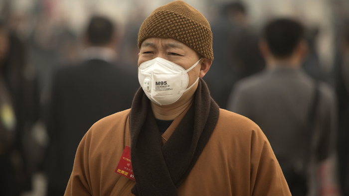 In this March 4, 2016 photo, a participant wearing a face mask arrives for a meeting ahead of the opening session of the National People's Congress (NPC) at the Great Hall of the People in Beijing. (AP Photo/Mark Schiefelbein)